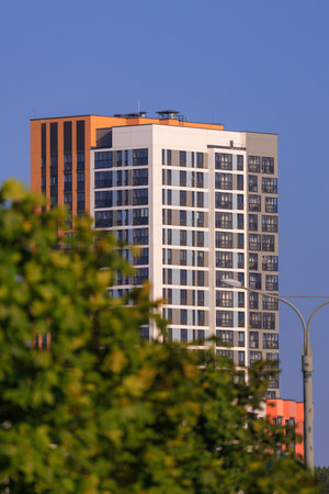 City view on a sunny day. Modern building and houses against the blue sky.の写真素材