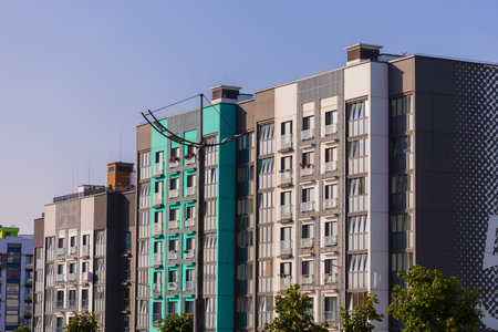 City view on a sunny day. Modern building and houses against the blue sky.