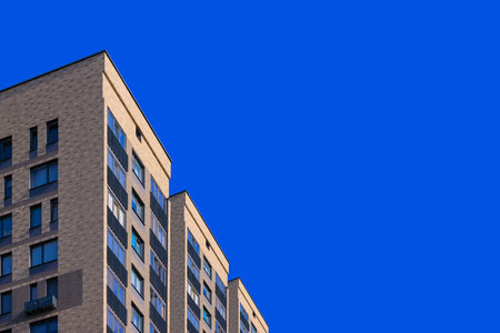 City view on a sunny day. Modern building and houses against the blue sky.