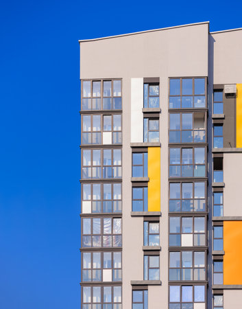City view on a sunny day. Modern building and houses against the blue sky.の写真素材