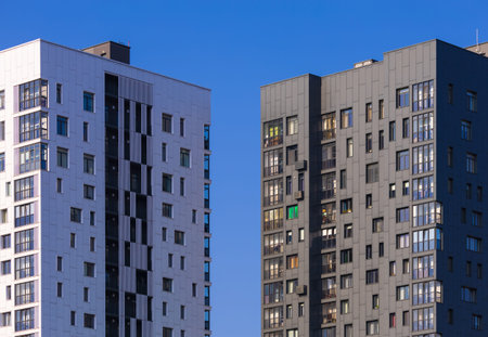 City view on a sunny day. Modern building and houses against the blue sky.