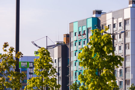 City view on a sunny day. Modern building and houses against the blue sky.