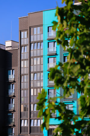 City view on a sunny day. Modern building and houses against the blue sky.の写真素材
