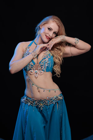 Woman in a blue costume dancer posing and dancing on a black backgroundの写真素材