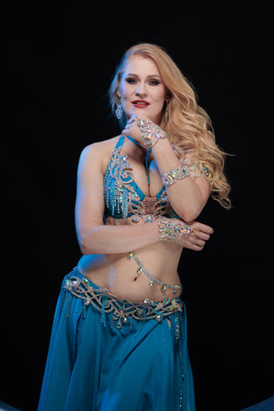 Woman in a blue costume dancer posing and dancing on a black backgroundの写真素材