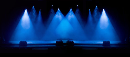 An empty stage of the theater, lit by spotlights and smoke before the performance