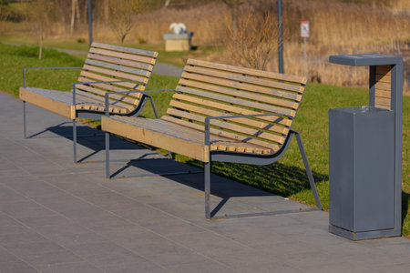 Wooden benches and chaise lounges for rest on the streets of the city and in the park, public placesの写真素材