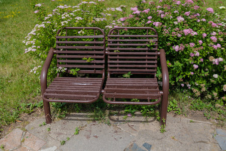 Wooden benches and chaise lounges for rest on the streets of the city and in the park, public placesの写真素材