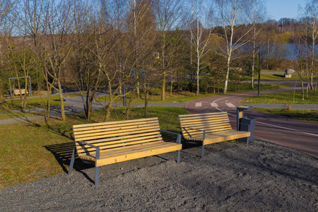 Wooden benches and chaise lounges for rest on the streets of the city and in the park, public placesの写真素材
