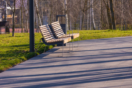Wooden benches and chaise lounges for rest on the streets of the city and in the park, public placesの写真素材