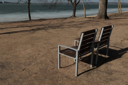Wooden benches and chaise lounges for rest on the streets of the city and in the park, public placesの写真素材