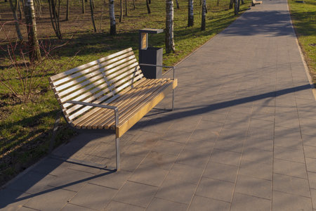 Wooden benches and chaise lounges for rest on the streets of the city and in the park, public placesの写真素材