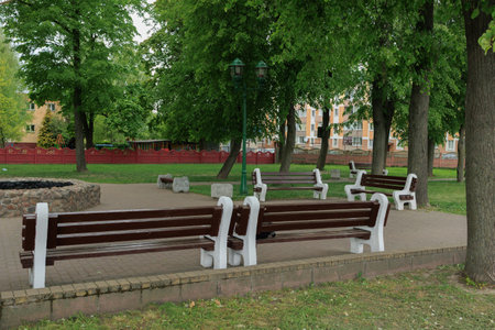 Wooden benches and chaise lounges for rest on the streets of the city and in the park, public placesの写真素材