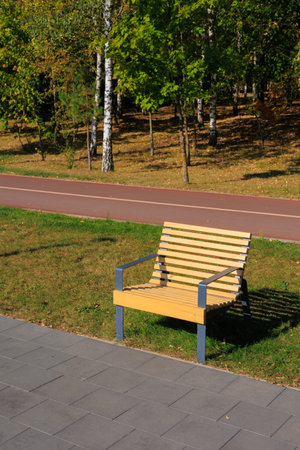 Wooden benches and chaise lounges for rest on the streets of the city and in the park, public placesの写真素材