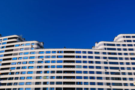 City view on a sunny day. Modern building and houses against the blue sky.