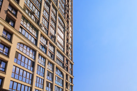 City view on a sunny day. Modern building and houses against the blue sky.の写真素材