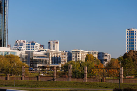 City view on a sunny day. Modern building and houses against the blue sky.の写真素材