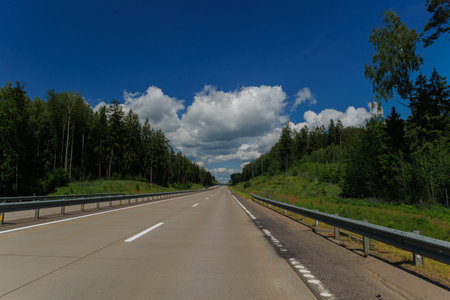 Road view on a summer day. Highways and roadside, white road line markings.