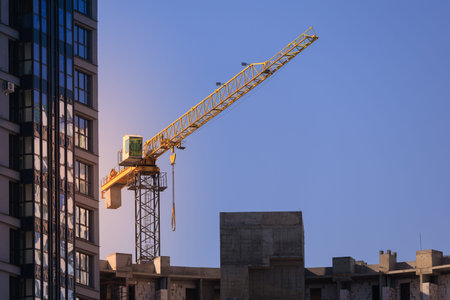 Construction of buildings and high-rise cranes against the evening sky