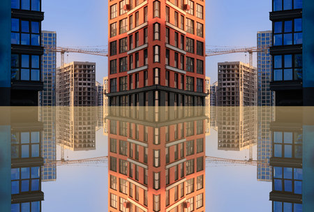 Construction of buildings and high-rise cranes against the evening skyの写真素材