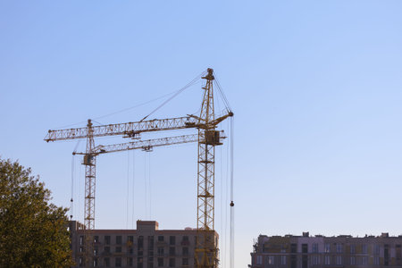 Construction of buildings and high-rise cranes against the evening sky