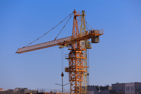 Construction of buildings and high-rise cranes against the evening sky