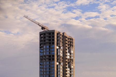 Construction of buildings and high-rise cranes against the evening skyの写真素材