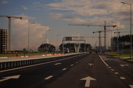 Construction of buildings and high-rise cranes against the evening skyの写真素材