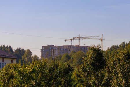 Construction of buildings and high-rise cranes against the evening skyの写真素材