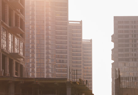 Construction of buildings and high-rise cranes against the evening skyの写真素材