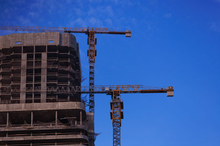 Construction of buildings and high-rise cranes against the sky