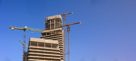 Construction of buildings and high-rise cranes against the sky