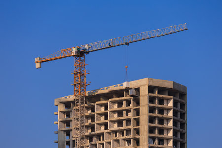 Construction of buildings and high-rise cranes against the evening skyの写真素材