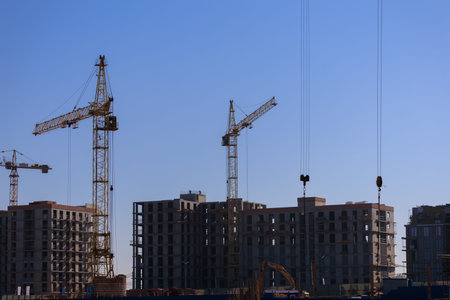 Construction of buildings and high-rise cranes against the sky