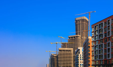 Construction of buildings and high-rise cranes against the sky