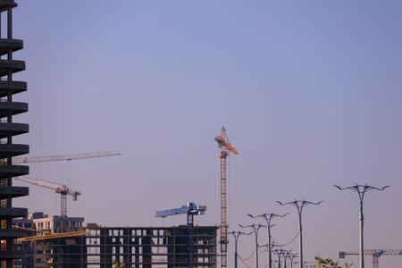 Construction of buildings and high-rise cranes against the sky