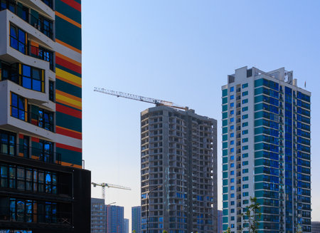 Construction of buildings and high-rise cranes against the evening skyの写真素材
