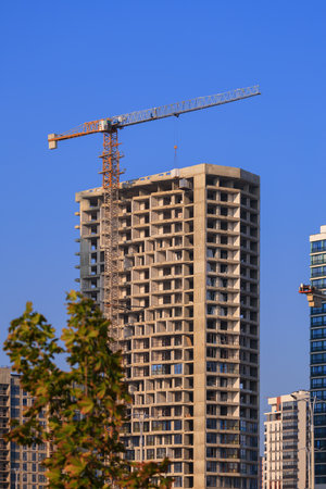 Construction of buildings and high-rise cranes against the skyの写真素材