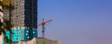 Construction of buildings and high-rise cranes against the skyの写真素材