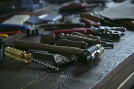 Tools for leather working on wooden table. Toolkit for leather workerの写真素材