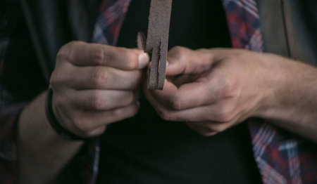 Thorough process. Close up of piece of leather in man hands leather worker that cuts into thin...