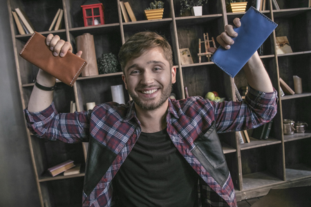 Man leather manufacturer smiling and holding two completed leather purseの写真素材