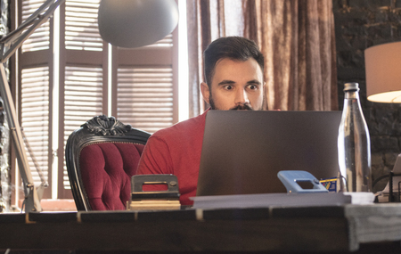 Young businessman sitting in office chair with laptopの写真素材