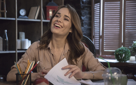 Young smiling businesswoman laughing and sitting in comfortable office chairの写真素材