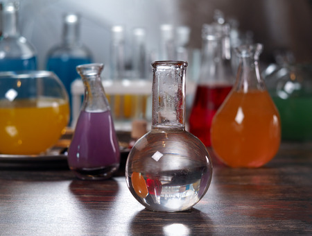 The bulb with clear water. Laboratory glassware with colorful liquids on the tableの写真素材