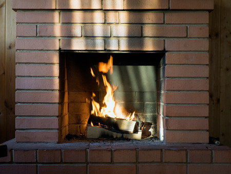 The brick fireplace firewood. Burning fire. Bright flamesの写真素材