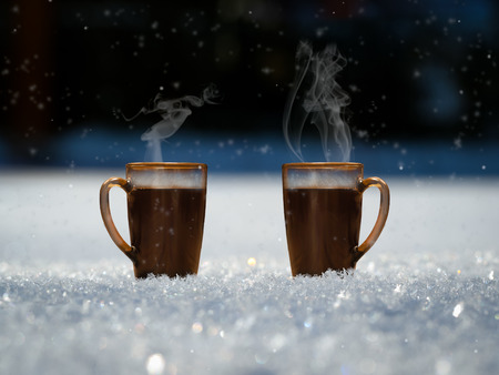 Two mugs with a hot drink on the street in the snow. Over cups of steam. Snowflakes fallの写真素材