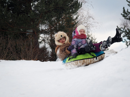 Happy kids riding a roller coaster on the tubing. Winter, snowの写真素材