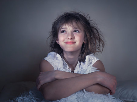 Good morning. Sleepy disheveled girl sitting on the bed. Smile, dreamy expressionの写真素材