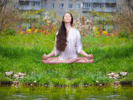 Beautiful girl is engaged in yoga. Meditation on nature in the city Parkの写真素材
